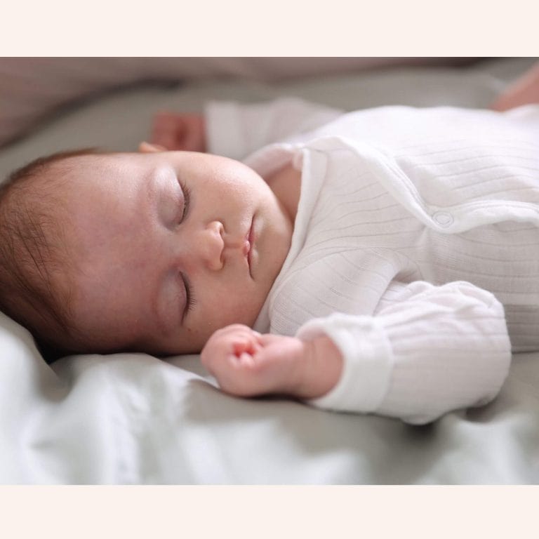 Nouveau-né endormi paisiblement sur matelas blanc