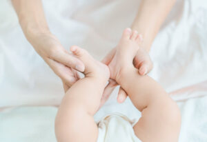 Mains d'un parent tenant tendrement les pieds nus de son bébé