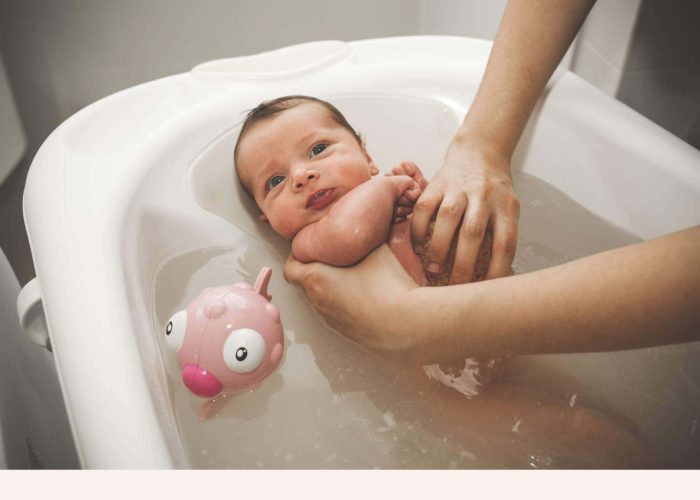 Nouveau-né dans baignoire bébé avec jouet de bain