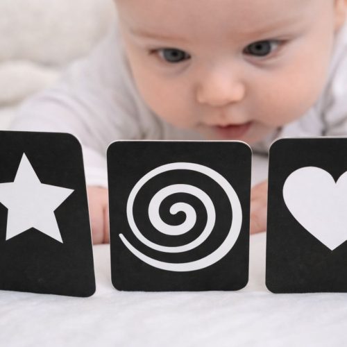 Bébé concentré devant des cartes contrastées noir et blanc