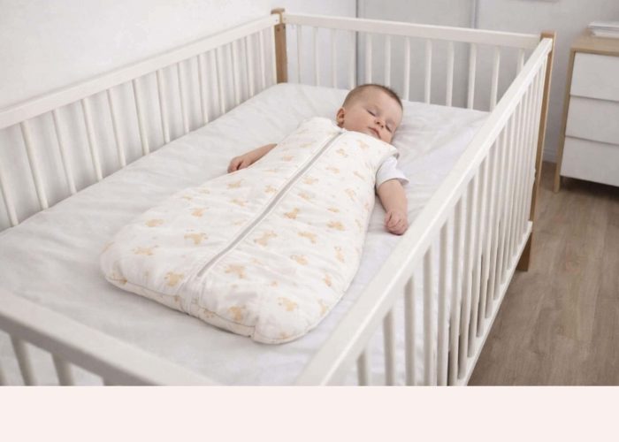 Bébé dormant sur le dos dans un lit à barreaux sécurisé avec gigoteuse