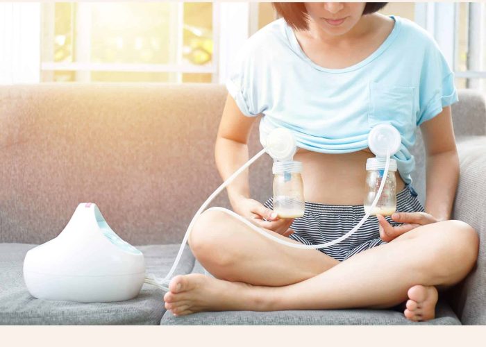 Maman utilisant un tire-lait électrique double à domicile